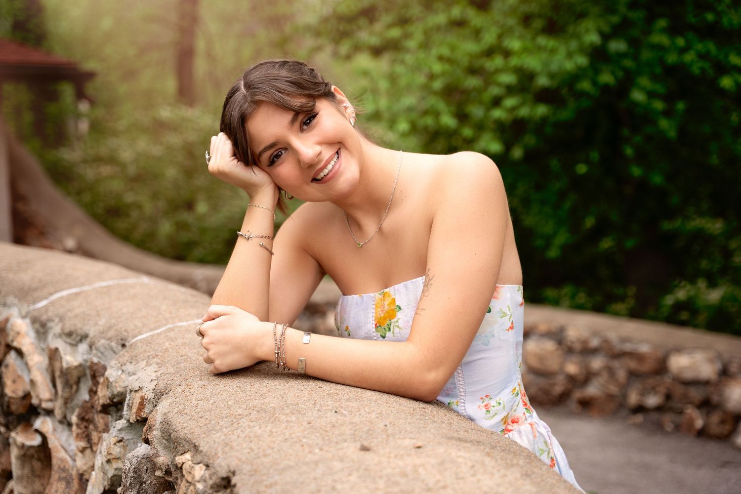 A series of outdoor portrait photographs showing someone resting on stone walls in a natural garden setting.