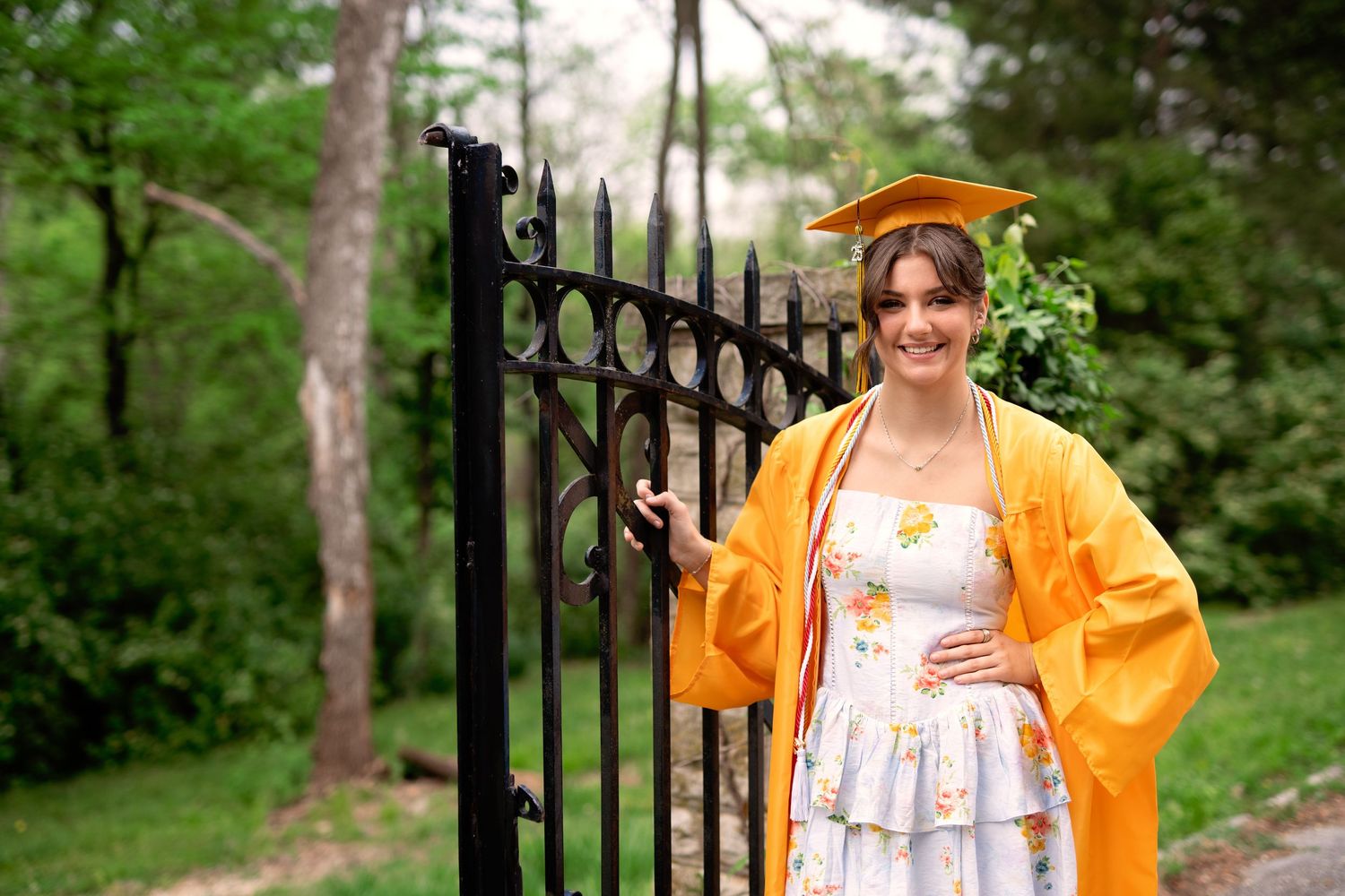 A collection of outdoor photos featuring someone in a white dress and yellow cardigan posing by an iron gate.