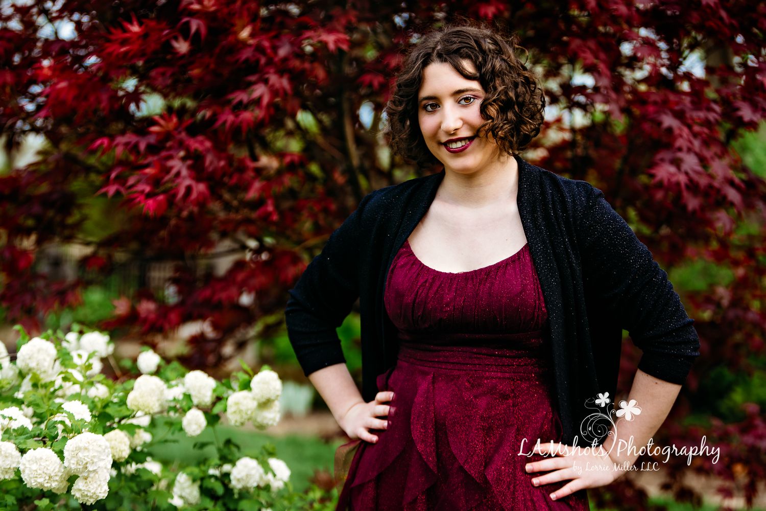 high school senior standing in front of flowers