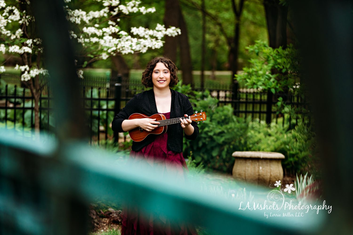 Shoot through portrait senior girl playing ukulele