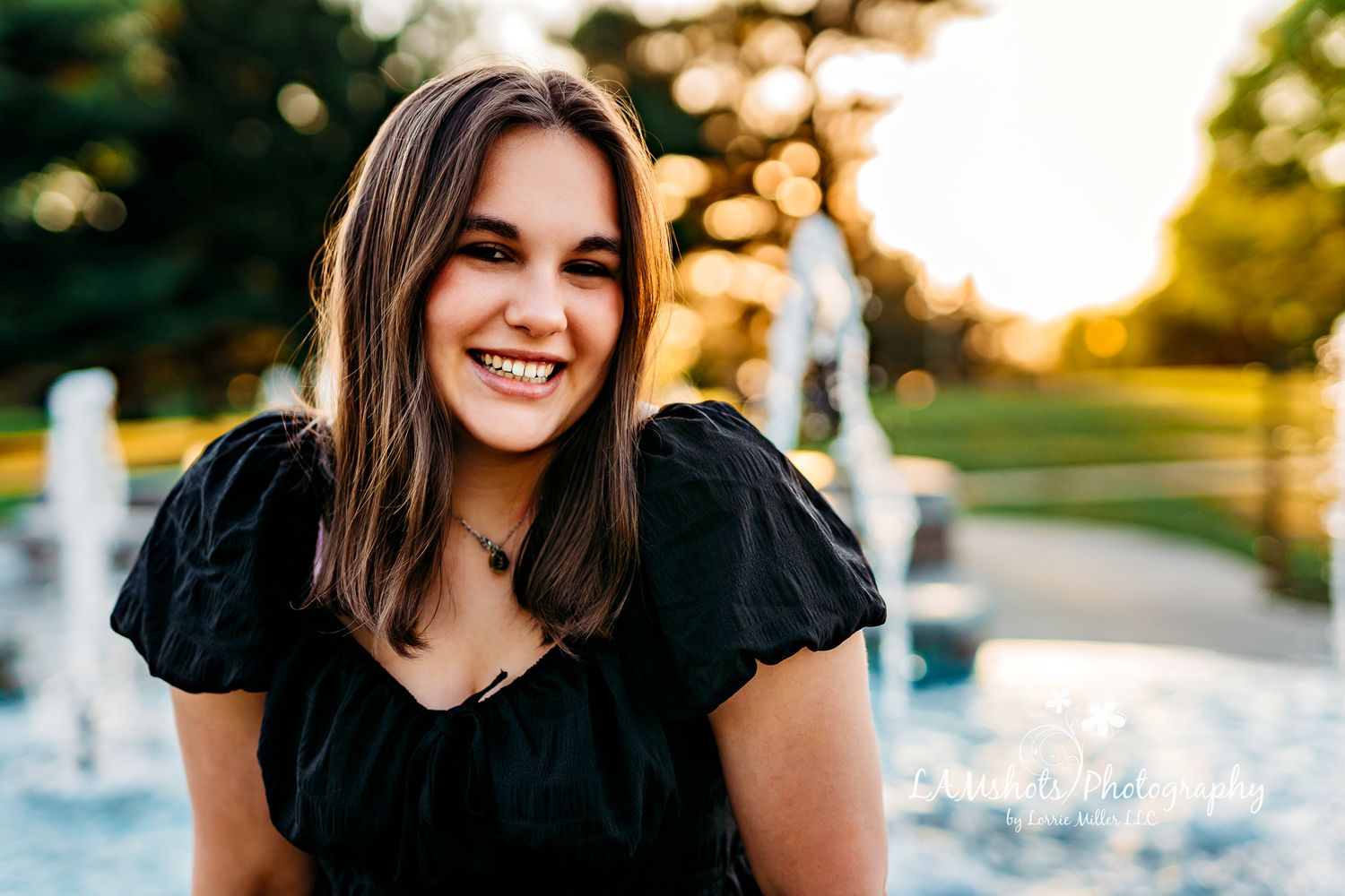 high school senior girl sitting in front of fountain Nathaniel Greene Park