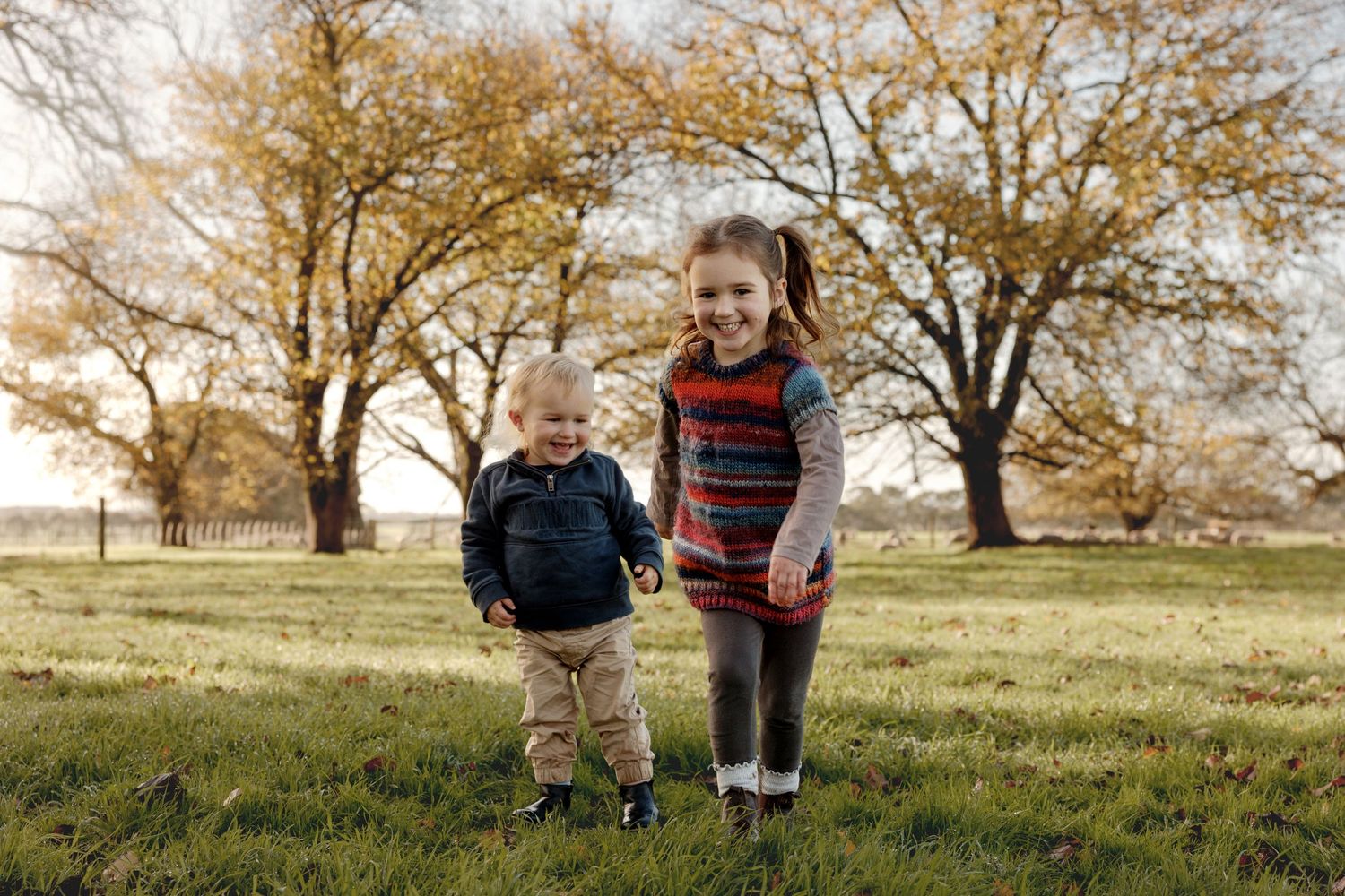 A joyful moment of laughter and play between mother and child outdoors.