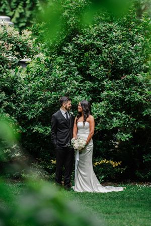Couple celebrating their wedding day in an intimate garden setting with lush greenery and natural lighting.