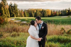 A couple in wedding attire shares romantic moments in a golden autumn field at sunset.