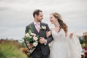 A wedding couple sharing joyful moments together in a natural outdoor setting with soft lighting and floral details.