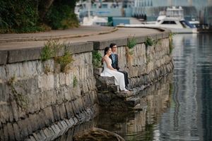 People sitting on canal wall in venice enjoying a quiet evening by the reflective water.