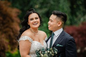 A heartwarming wedding portrait showcasing a joyful moment with natural greenery.