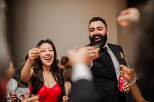 Festive wedding reception scene with guests raising glasses in celebration.