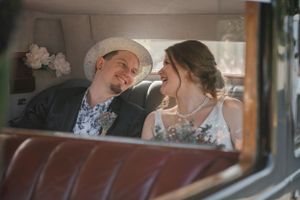 Couple shares joyful moment inside vintage car with delicate interior details.
