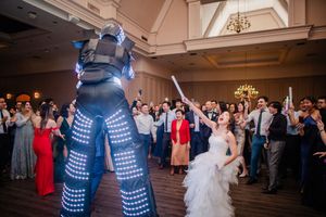 Couples dancing together at an elegant wedding reception in a grand ballroom with soft lighting and formal attire.