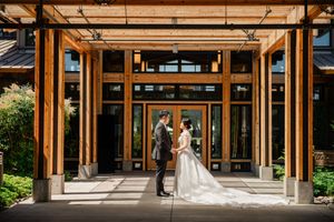Modern architectural venue with wooden beams and glass walls creating an elegant wedding ceremony space.