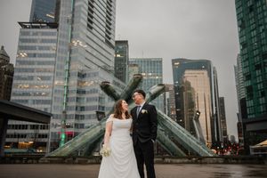 Newlyweds share romantic moments against a backdrop of modern city architecture and skyscrapers.