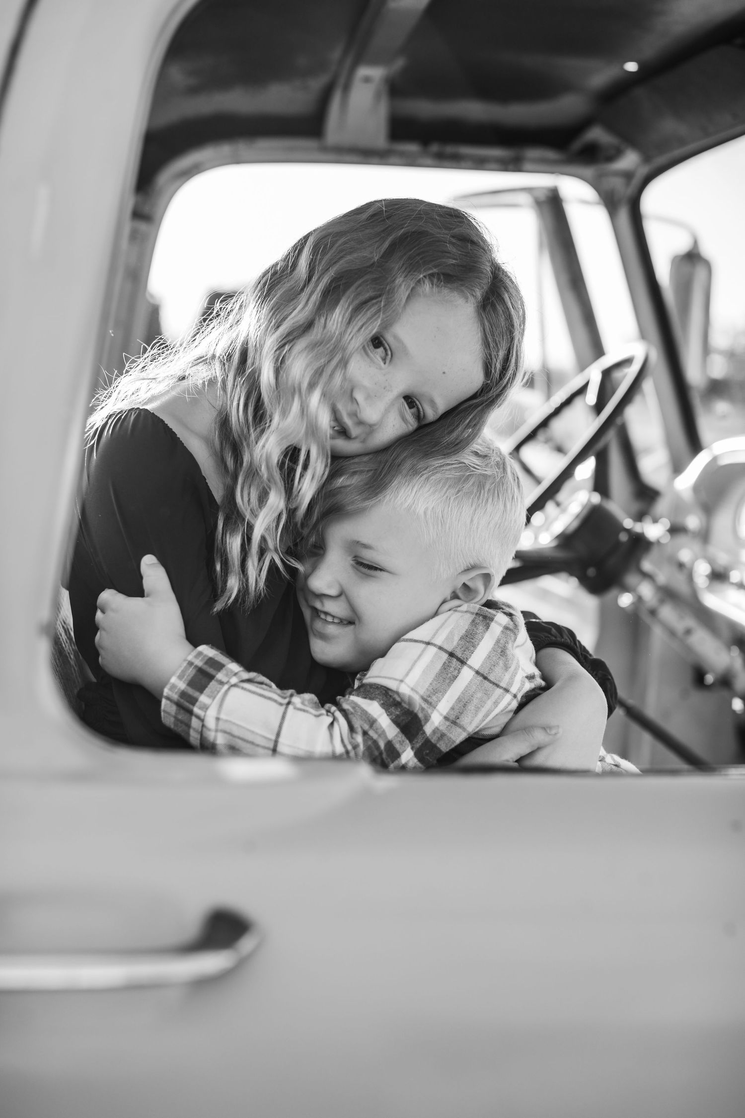 A heartwarming moment captured through a vehicle window showing affection and laughter.