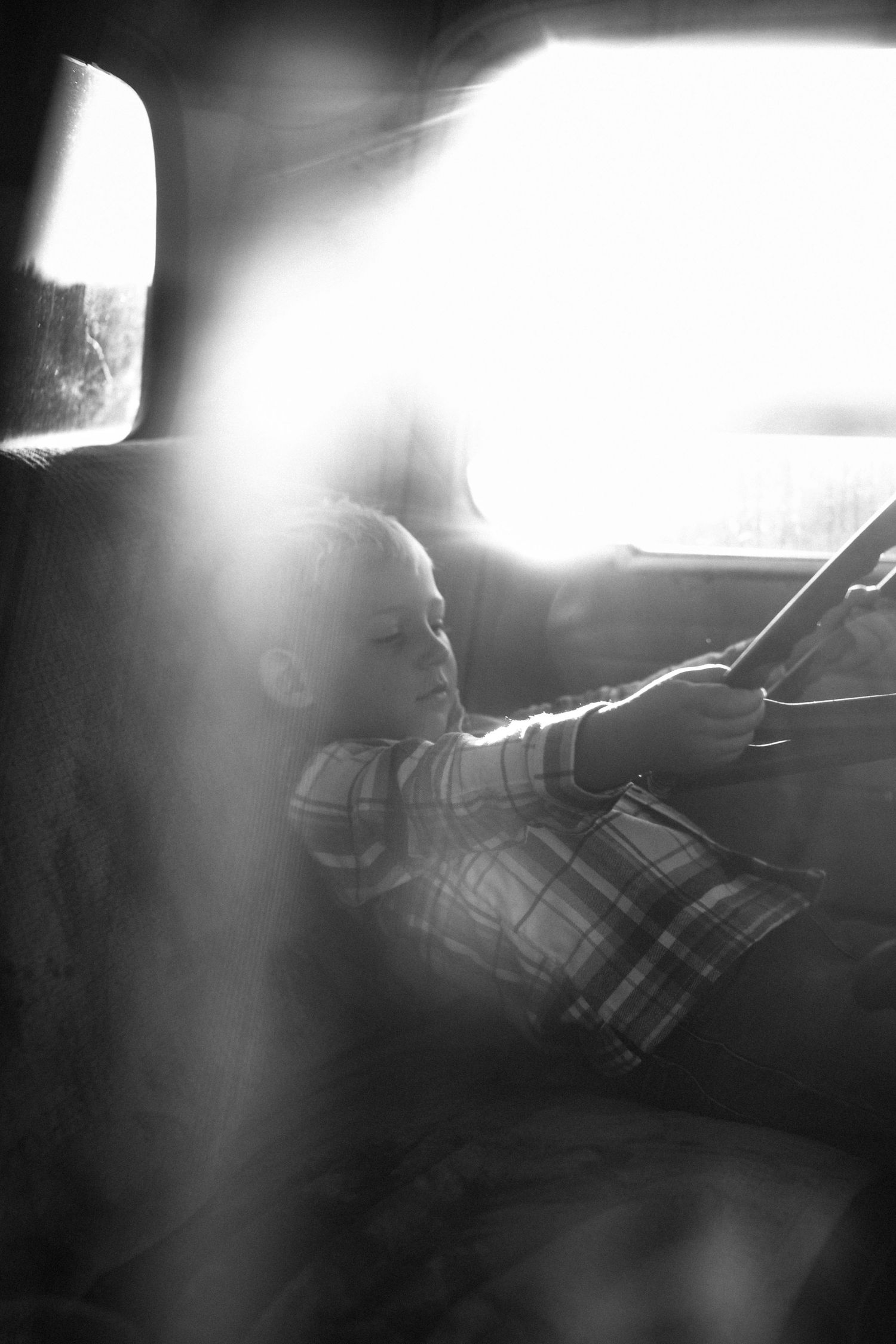 Artistic black and white photo of sunlight streaming through a vehicle window.