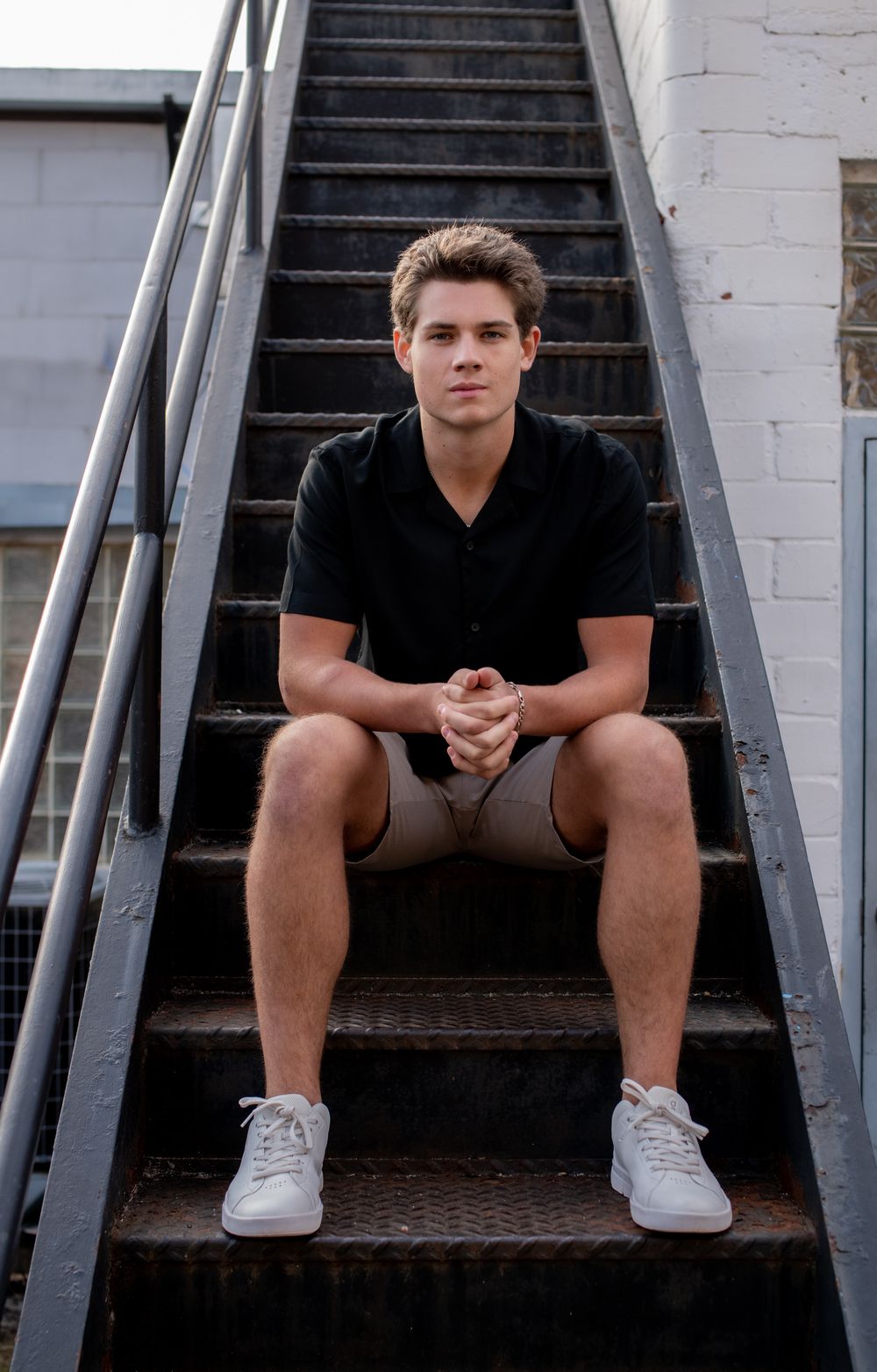 Three similar shots of a person sitting on outdoor metal stairs wearing a black shirt and white sneakers.