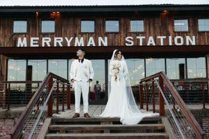 Wedding couple standing on steps in front of Merryman Station sign.