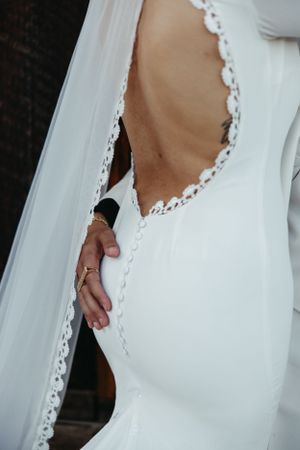 Close-up detail of delicate lace trim on a white wedding dress.