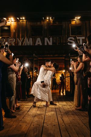 A romantic wedding couple dancing at the Ryman venue while guests with cameras line the sides.