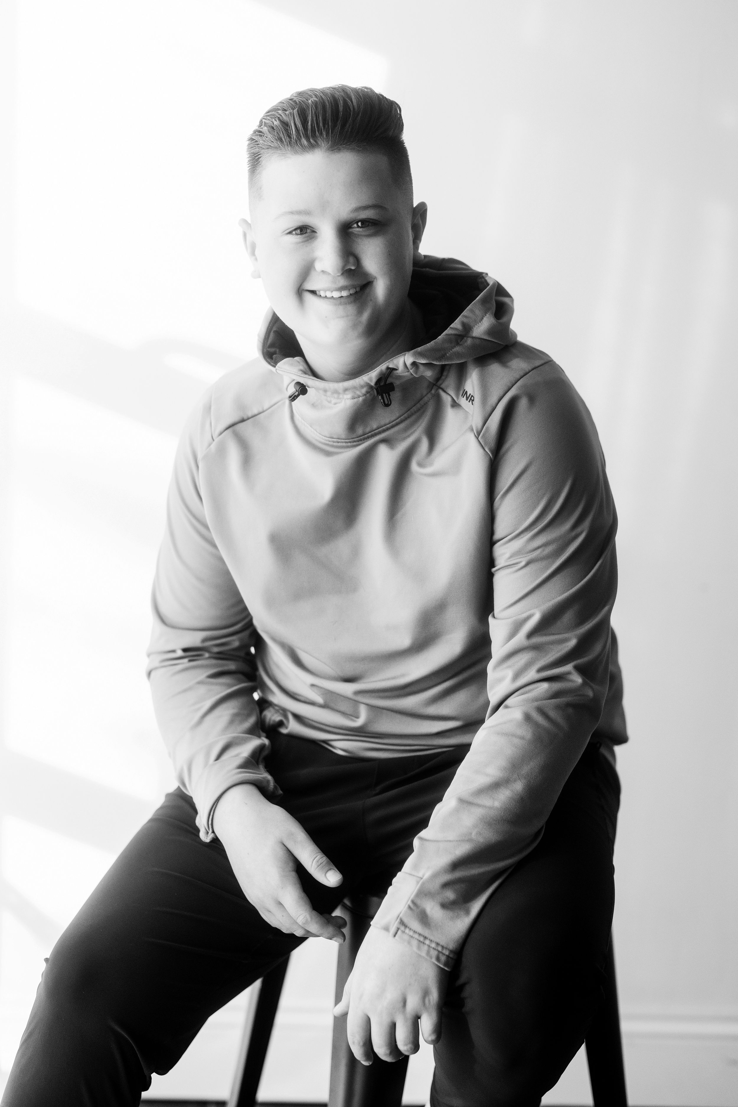 A series of black and white studio portraits showing a person in a light-colored sweatshirt against a white background.