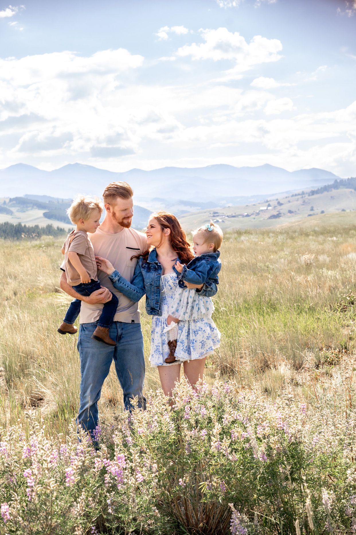 A group posing together in a scenic autumn field with golden grass and blue sky.