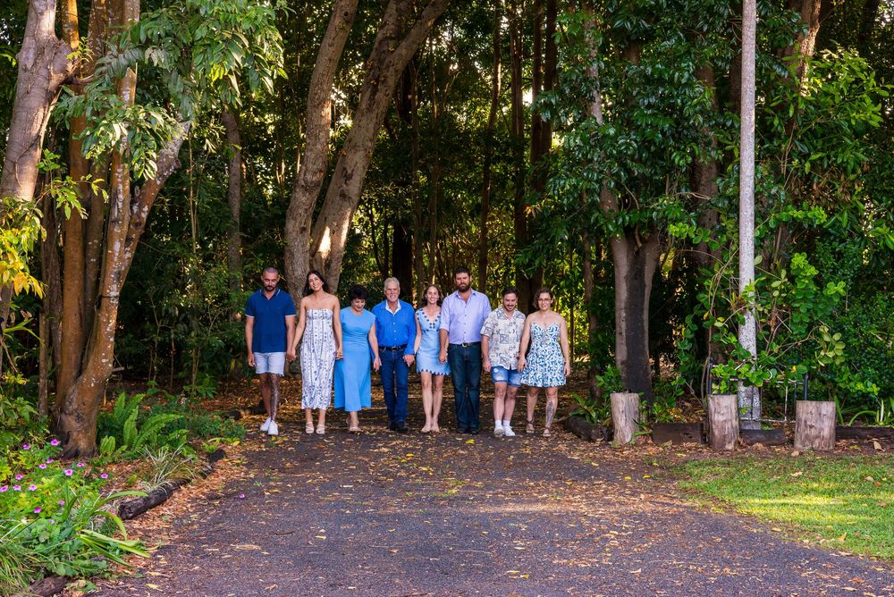 Large family group walking together along a wooded path during golden hour.