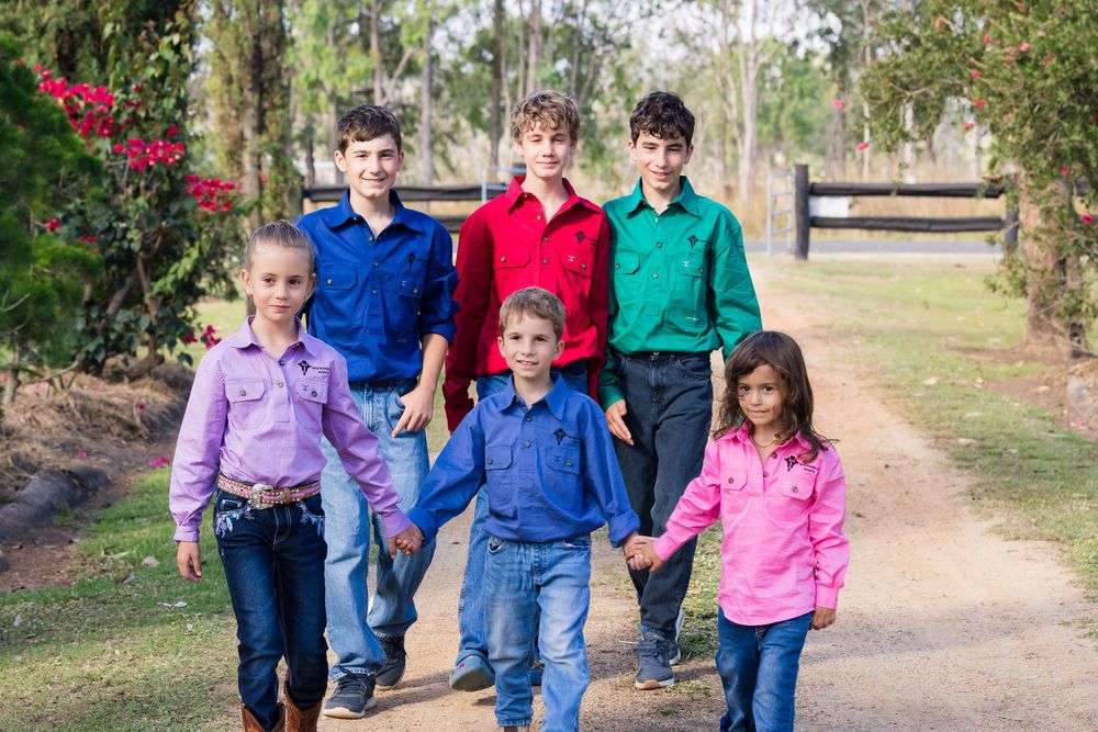 Happy family walking together on a dirt path through a wooded area on a sunny fall day.