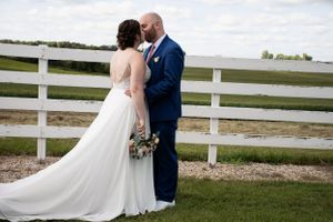 Bride and groom by fence