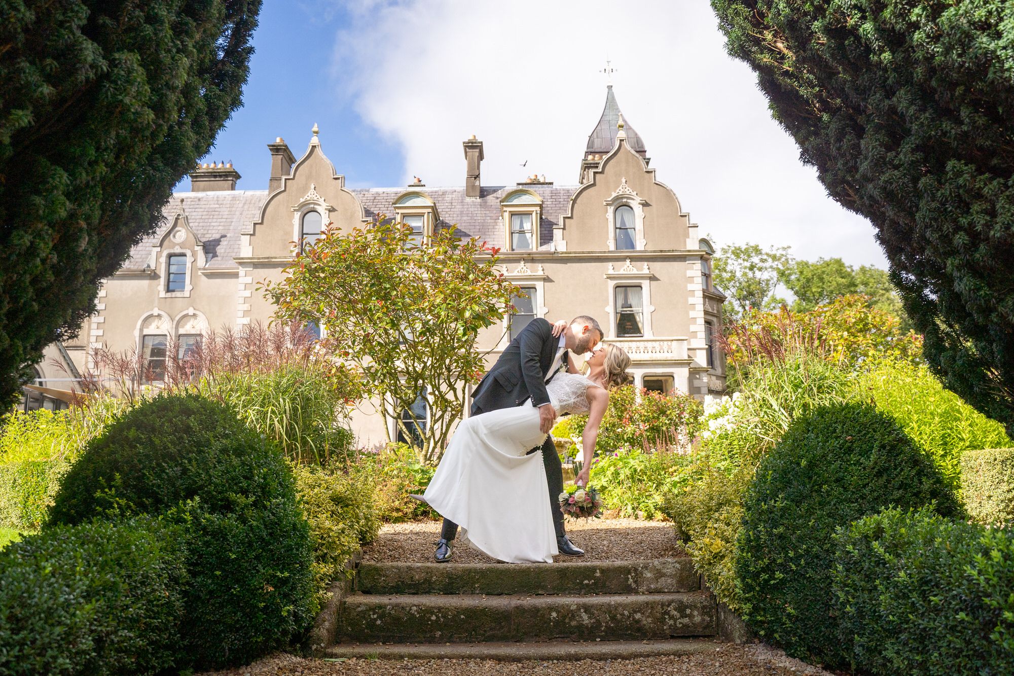 Bride and groom share a romantic dip kiss on garden steps outside Killashee house, Naas , County Kildare. Photo by AK wedding Photography