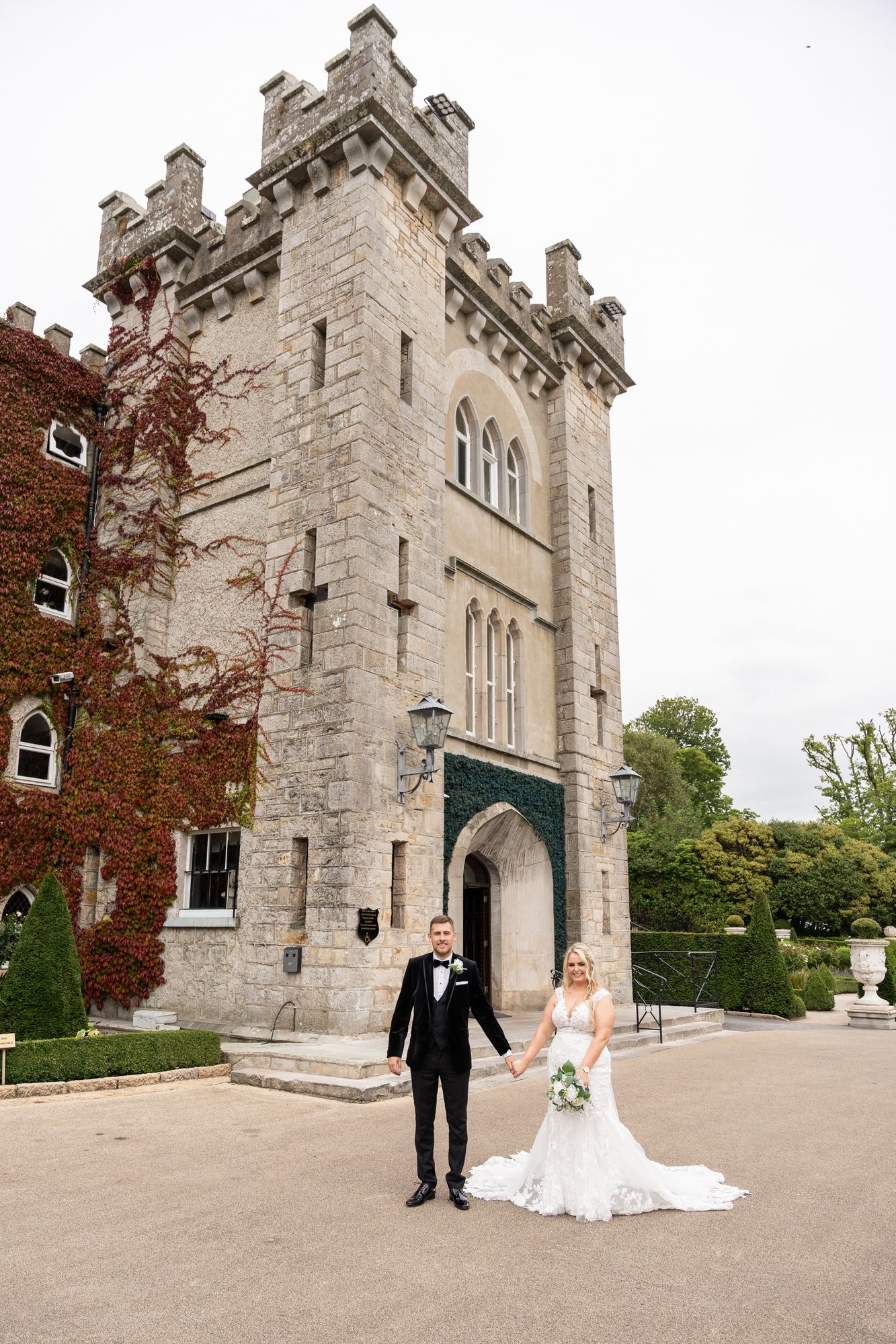 Bride and groom holding hands in front of a stunning Darver Castle, county Cavan taken by Anthony Kane of AK photography and Videography