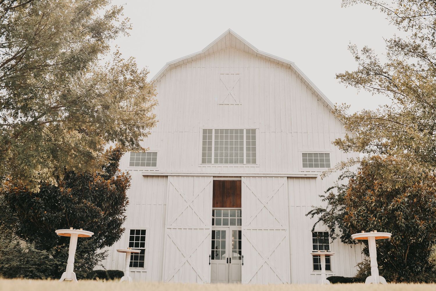 Wide view of The White Sparrow wedding venue with white barn and chapel