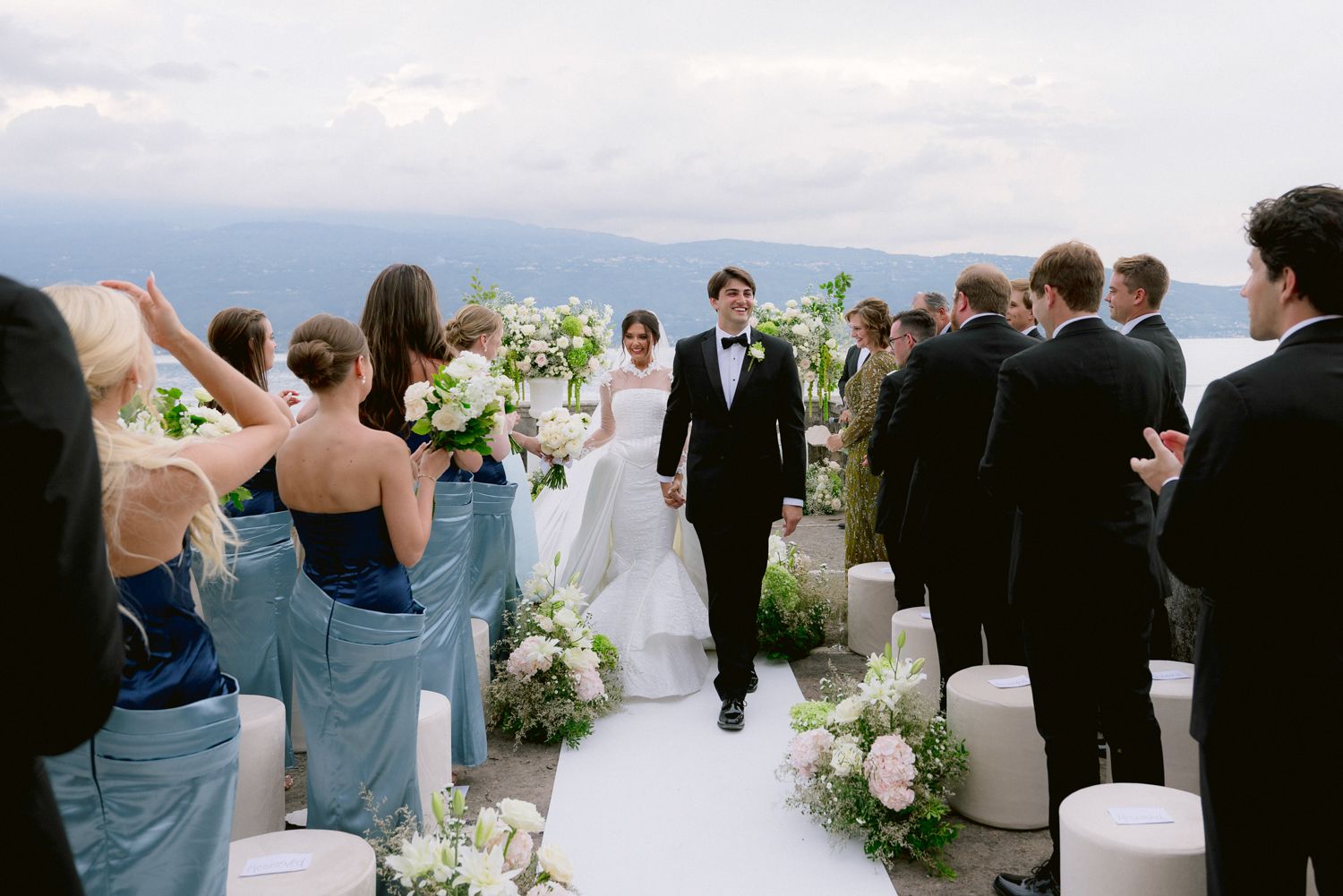 Bride and groom exiting their wedding ceremony on the lake view terrace of Villa Bettoni, Lake Garda, Italy. Design by Solidea Events