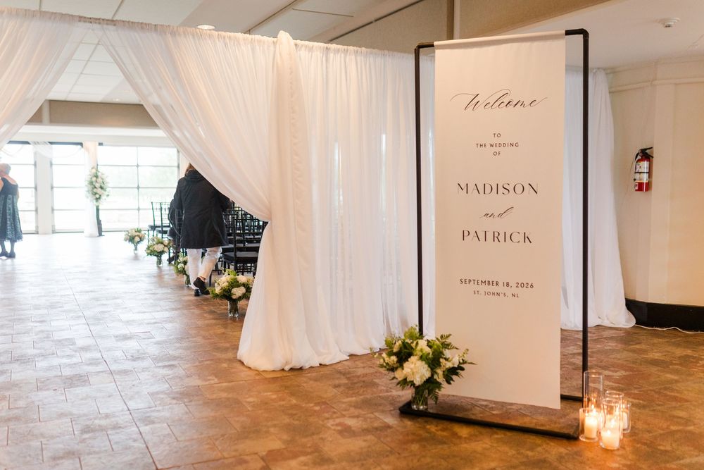 Elegant wedding welcome sign for Madison and Patrick displayed near white draping and floral arrangements.
