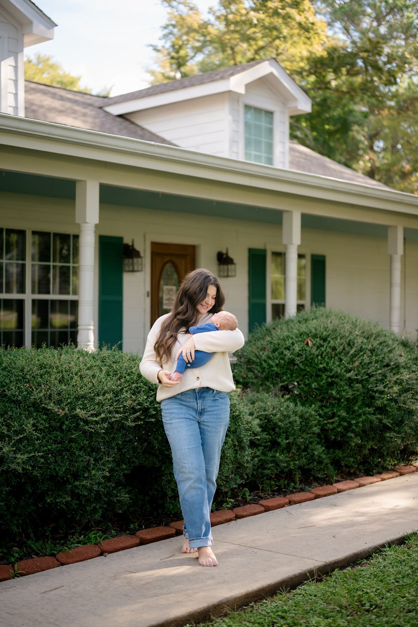 New mother cuddling her newborn son during an at-home photography session in Willis