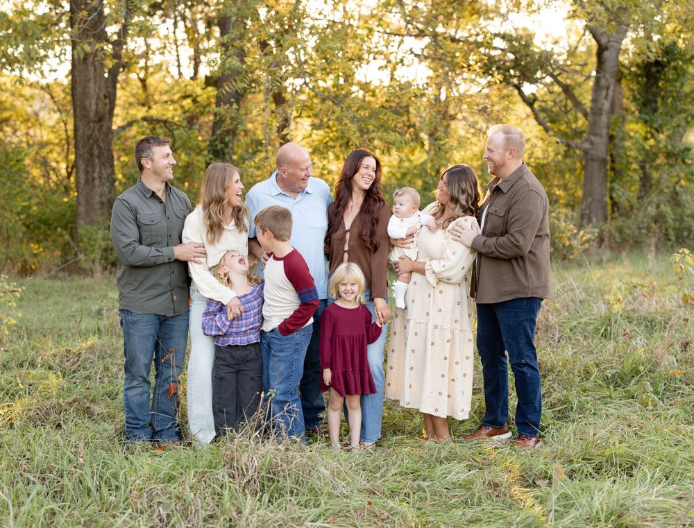 Extended family laughing together during an outdoor photo session in Defiance, Missouri