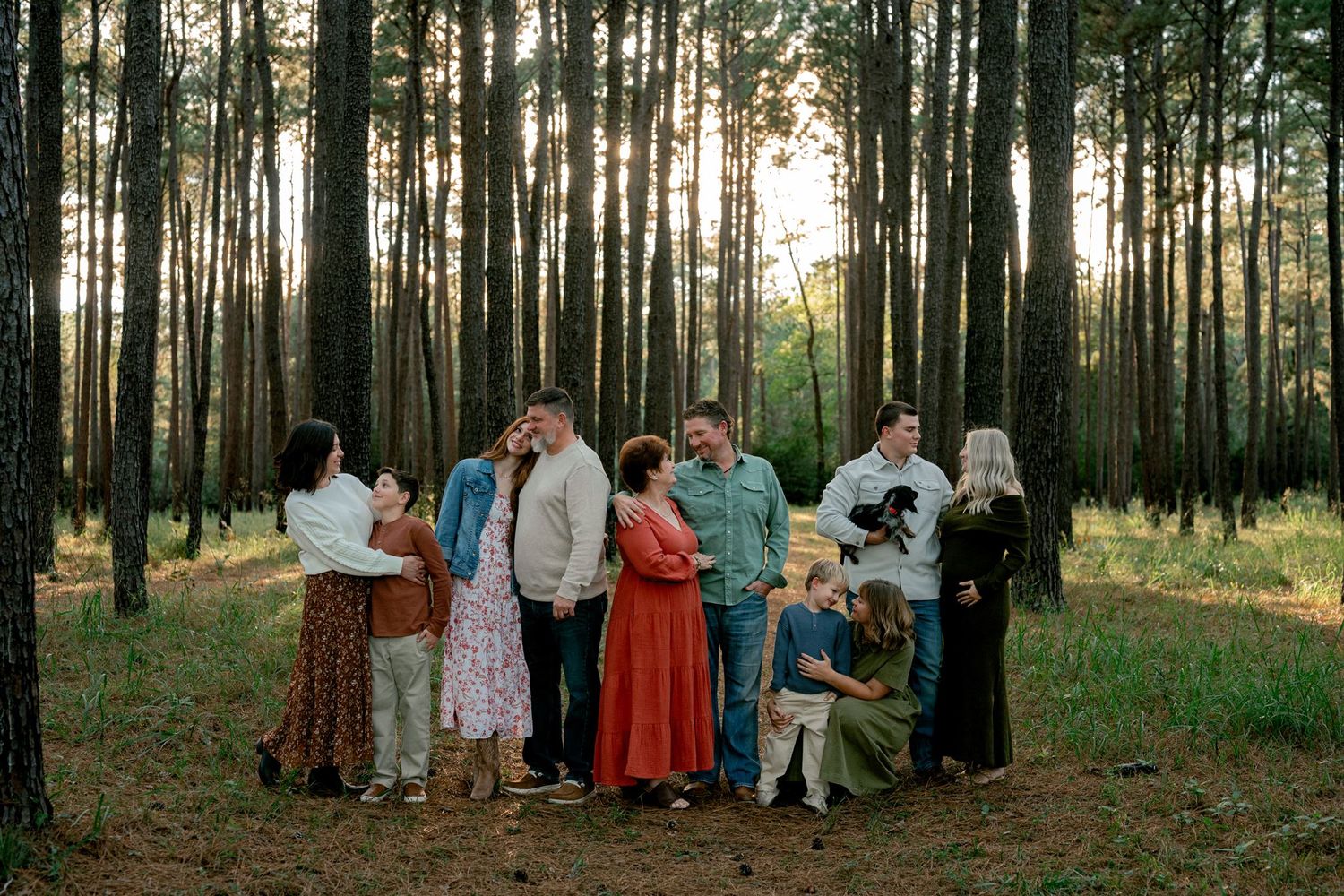 Multigenerational family portrait beneath tall pine trees at W.G. Jones State Forest.