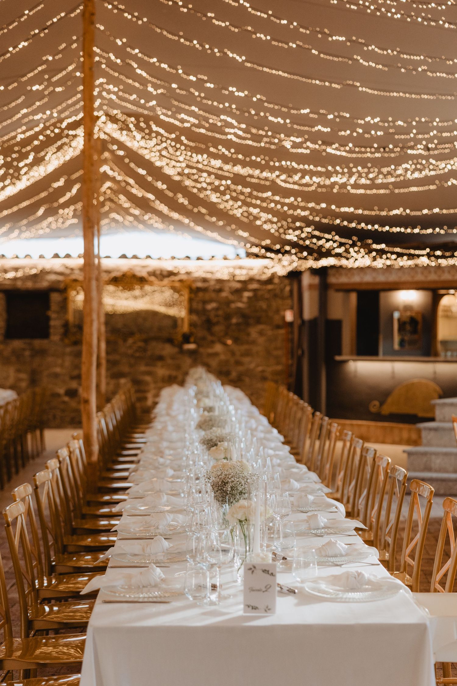 La tavola del ricevimento al Boda de Ciondro sotto una trama di luci.