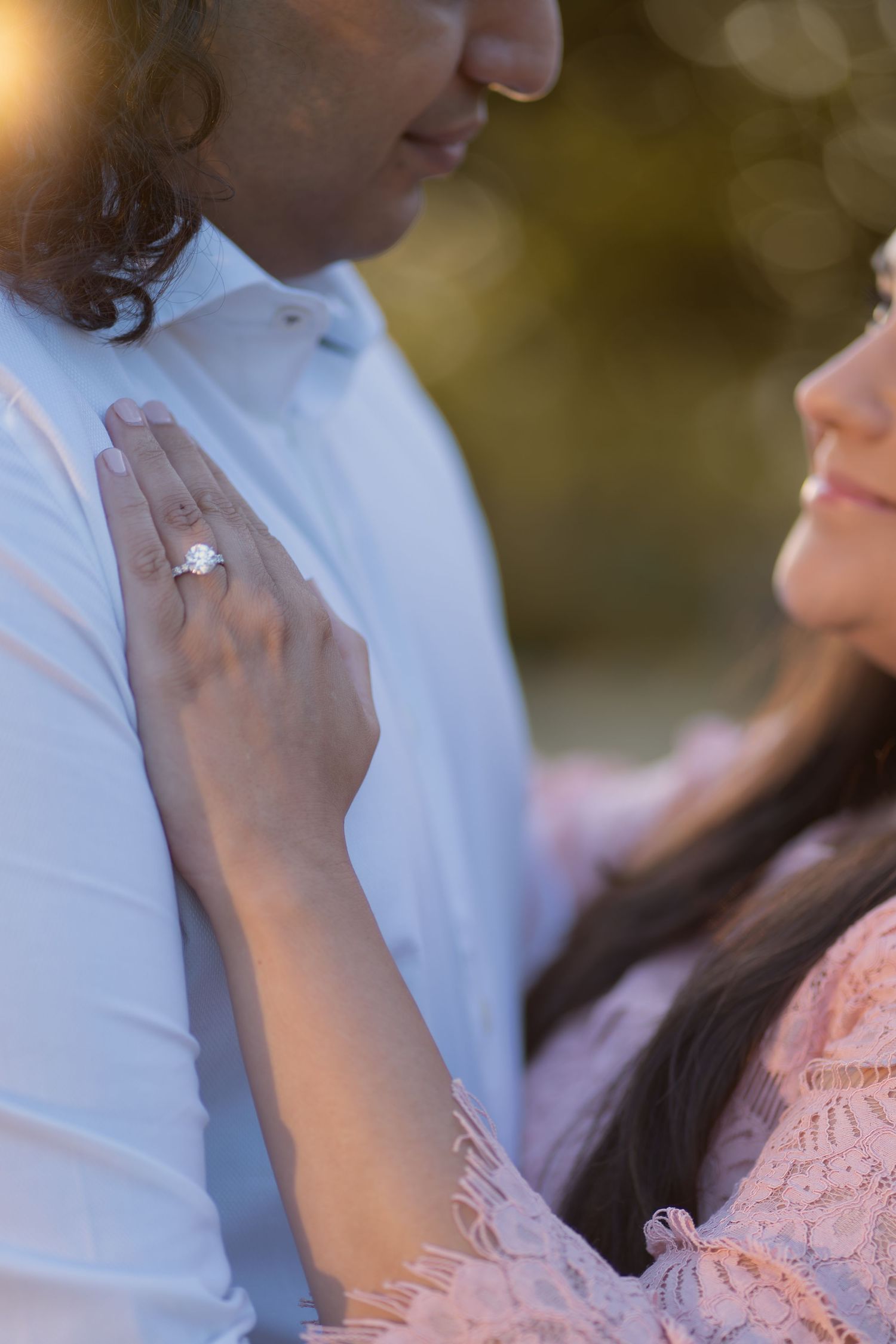 Couple posing at golden hour sunset with mountain and forest backdrop in a romantic outdoor portrait.
