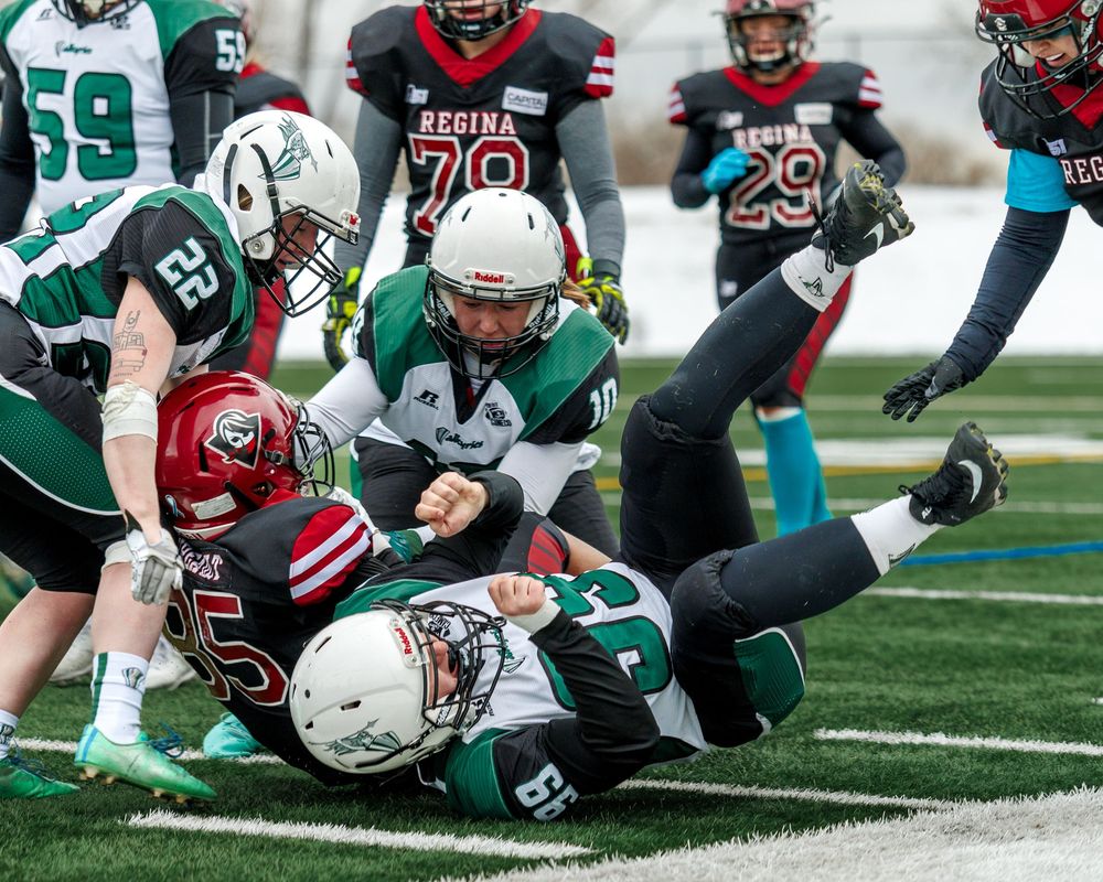 Regina Riot player tackled to the ground by opposing team during a football game.