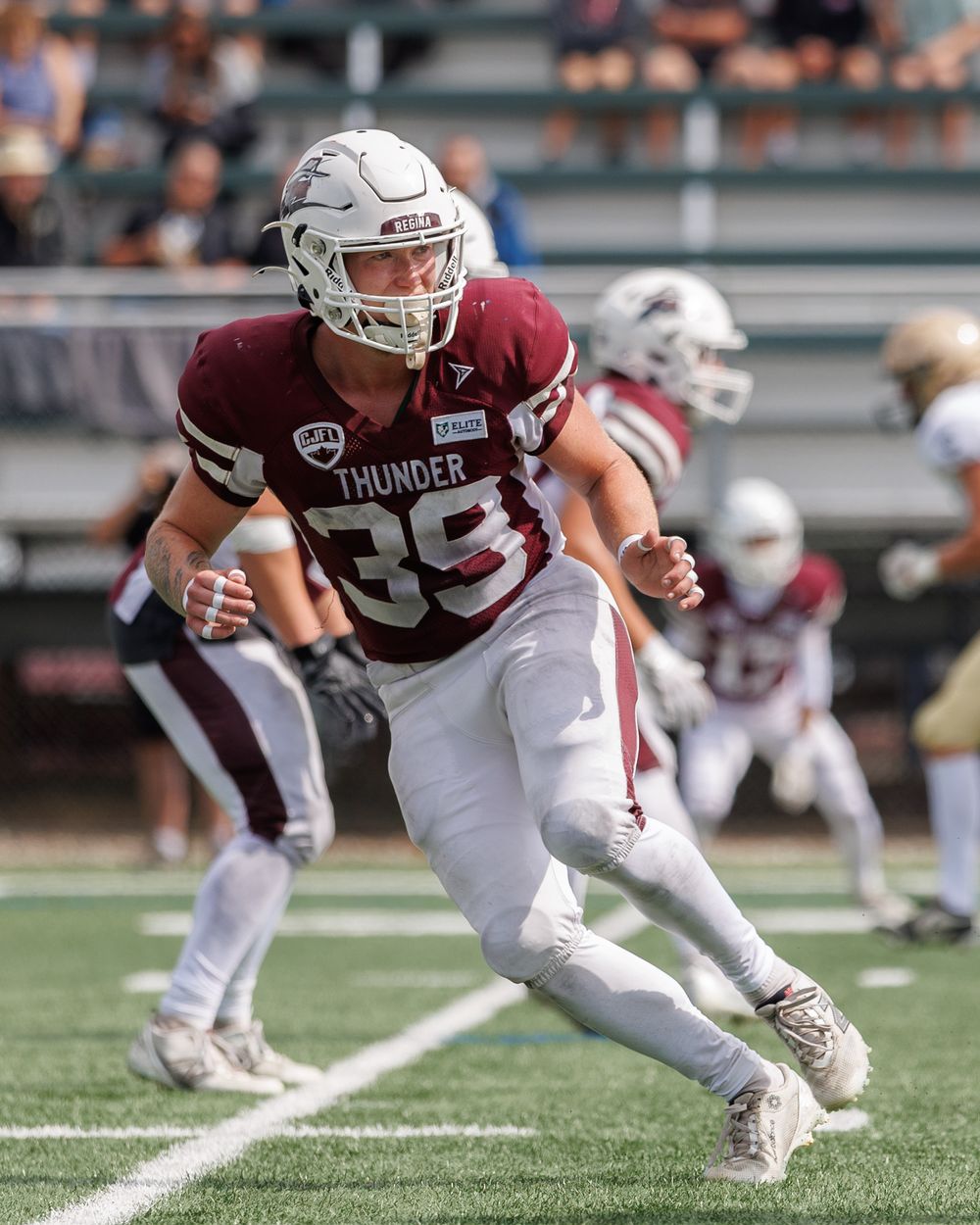 Thunder football player number 39 in maroon uniform sprints across the field during a competitive game.