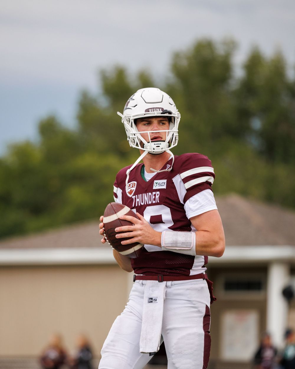 Thunder quarterback wearing maroon and white uniform prepares to throw the football during a game.