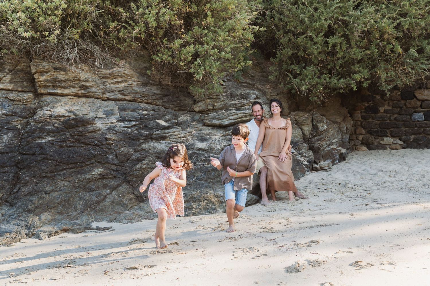 Enfants courant sur la plage pendant une séance photo famille naturelle