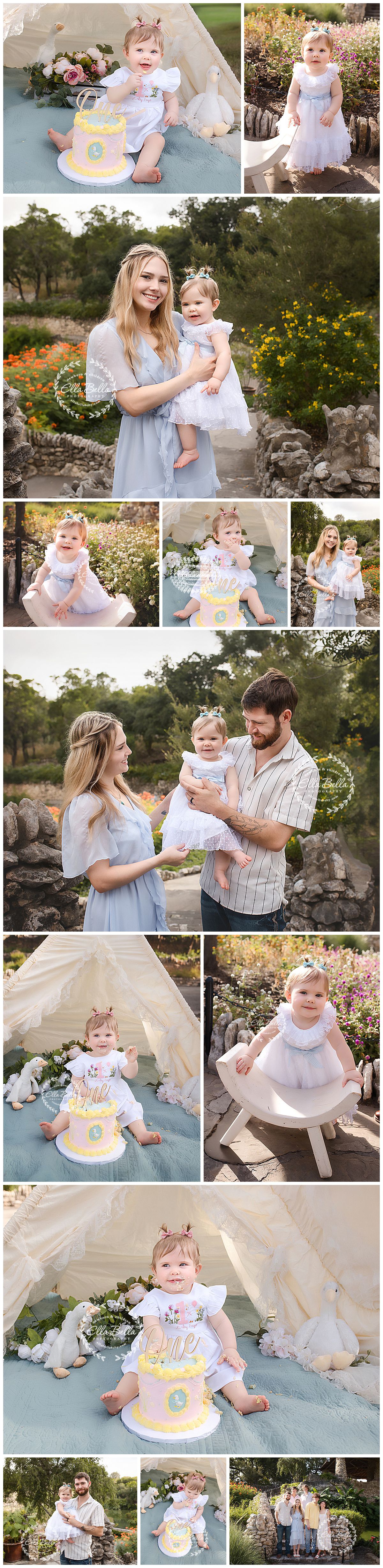 A baby girl in a white dress celebrates her first birthday with cake smash photos in a garden with her smiling parents.