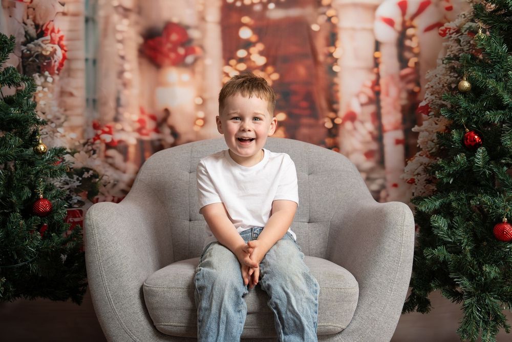 boy laughing on a chair in Christmas setting