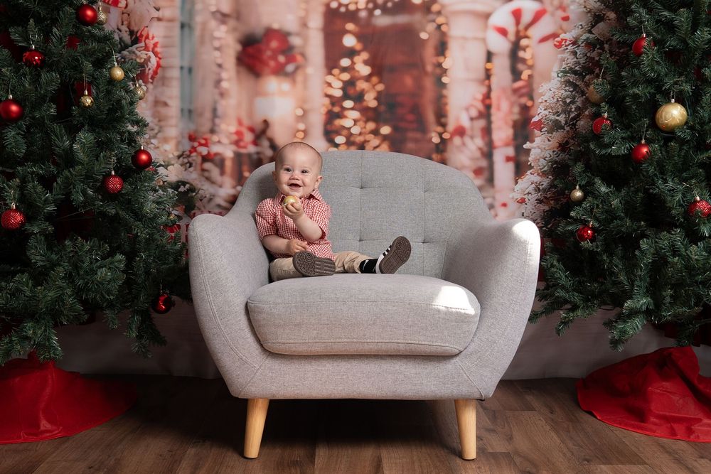 baby sitting on a chair in a christmas photo setting