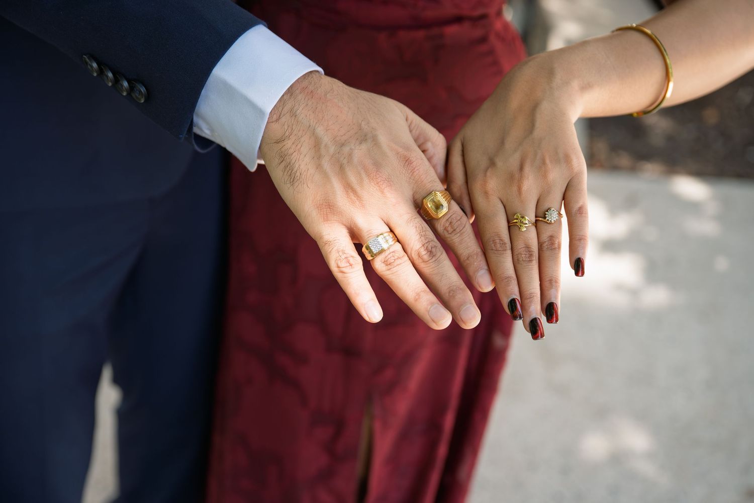 Couple posing for photo of their wedding bands during a couple engagement wedding portrait session. They are showing their hands to camera