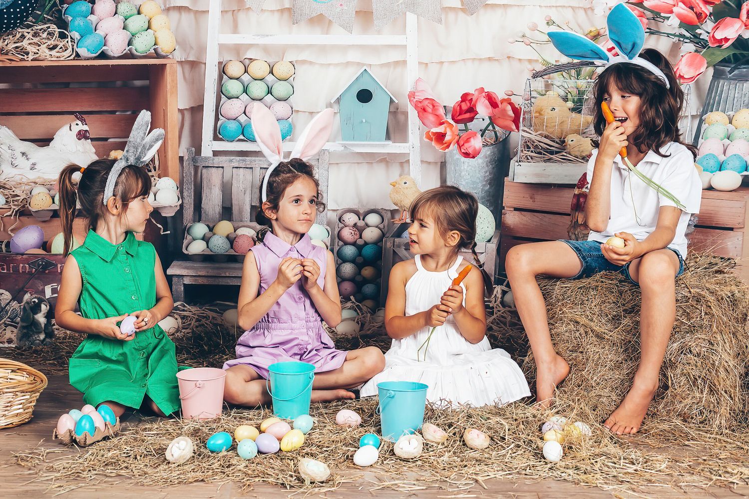 Children wearing bunny ears sitting together among Easter eggs during a colourful seasonal studio session
