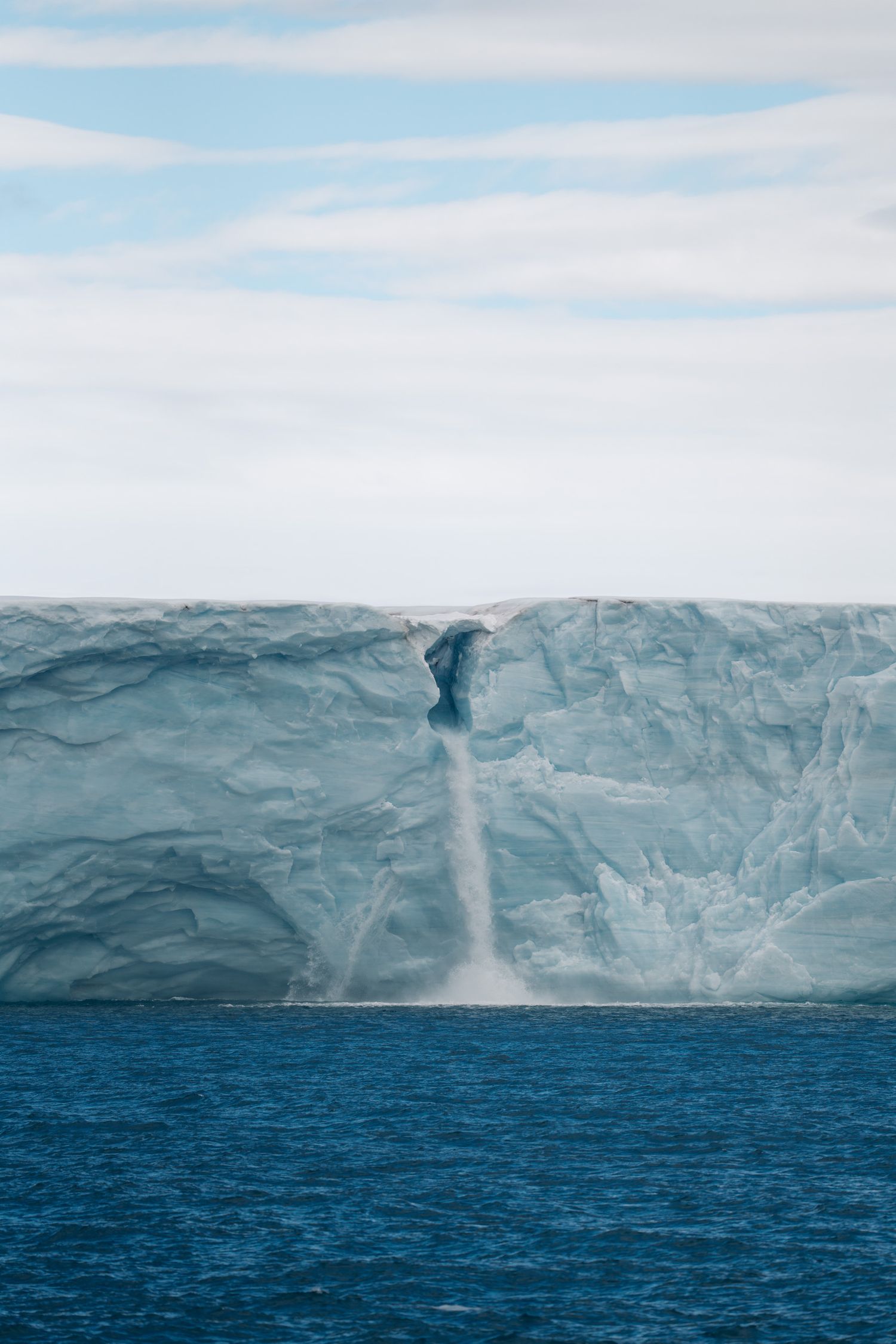 Cascade d'eau de fonte tombant de la barrière de glace de Bråsvellbreen
