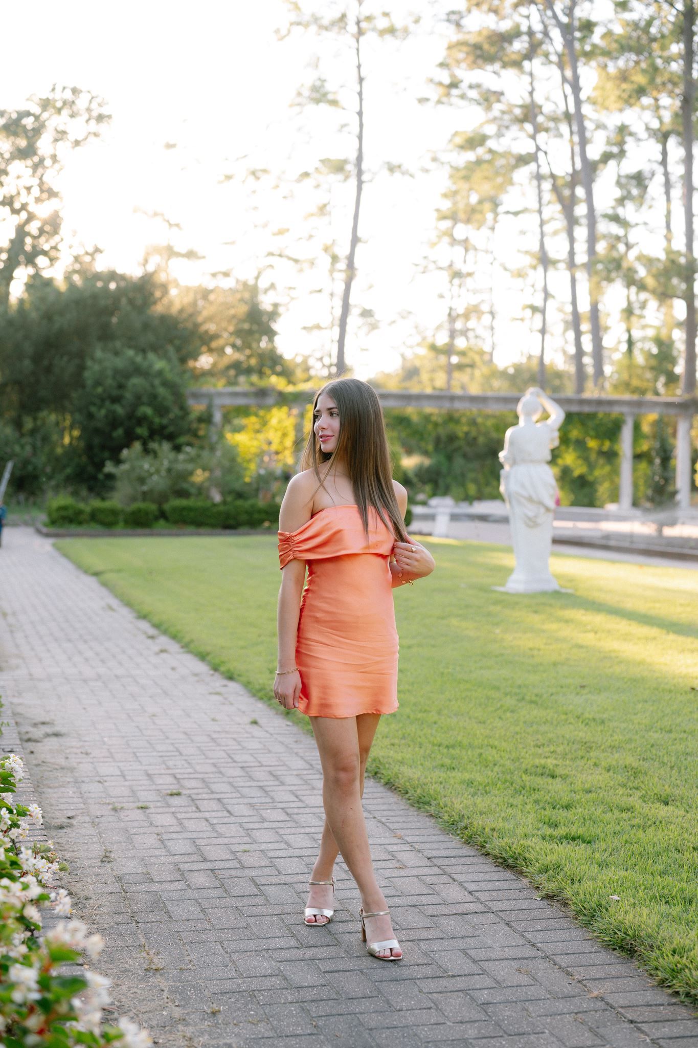 College Park High School senior girl, wearing short orange dress, at Mercer Botanic Garden in Spring Texas.
