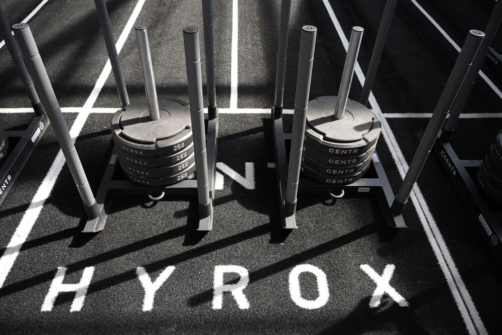 Overhead photograph of Hyrox sled stations arranged on the competition floor, showcasing the iconic equipment, clean geometry