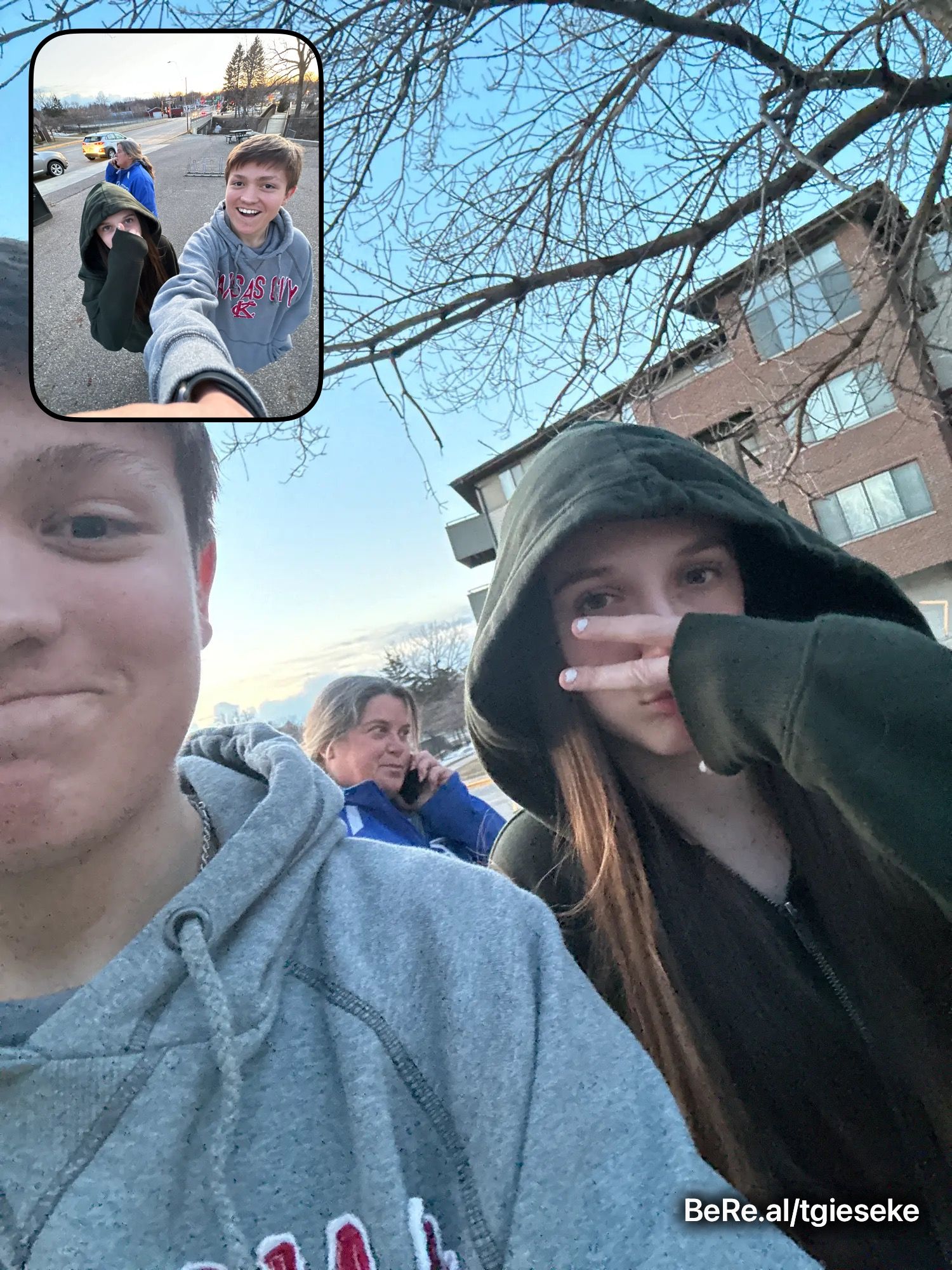 Two teens take a selfie outdoors near a building, with a inset photo showing a smiling boy on a video call.